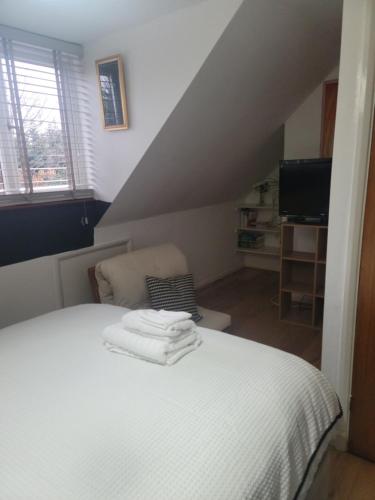 een slaapkamer met een bed met handdoeken erop bij The Bungalow in Kent