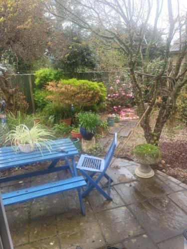 een blauwe picknicktafel en stoelen in een tuin bij The Bungalow in Kent