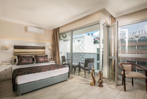 1 dormitorio con 1 cama y balcón en Arbatt Marmaris Hotel, en Marmaris