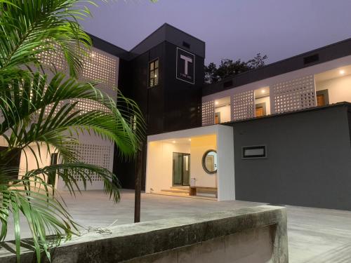 a black and white house with a palm tree at T-OneHome in Phetchabun