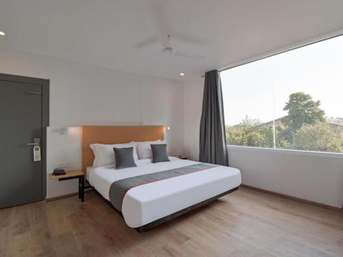 a bedroom with a large bed and a large window at Hotel Jaiman in Jaipur