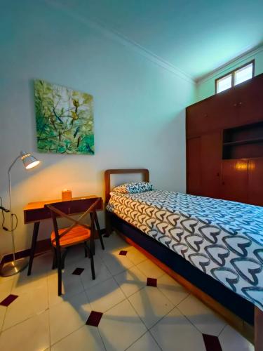a bedroom with a bed and a desk and a table at Sekar Tanjung in Yogyakarta