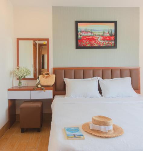 a bedroom with a bed with a hat on it at Canary Nha Trang Hotel in Nha Trang