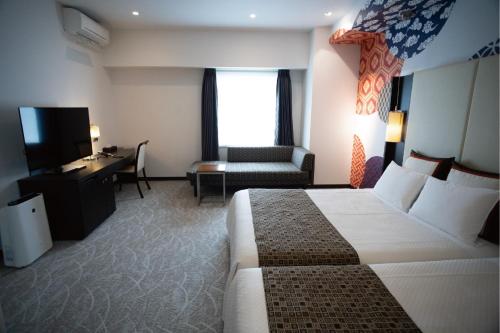 a hotel room with a bed and a desk at Hotel Bestland in Tsukuba