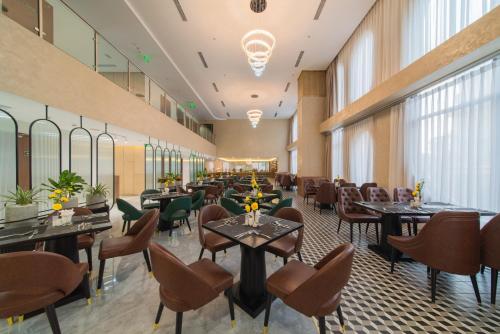 a restaurant with tables and chairs in a room at Grand Tourane Nha Trang Hotel in Nha Trang