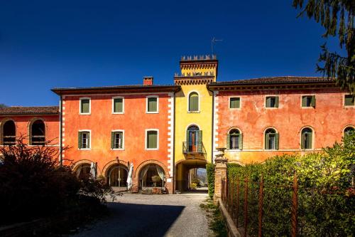 a large building with a tower on top of it at Villa Clementina - Prosecco Country Hotel in San Pietro di Feletto