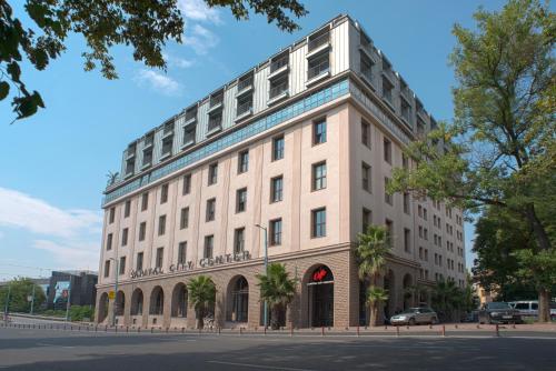 a large white building on the corner of a street at Capital City Center Apart Residence in Plovdiv