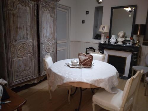 une salle à manger avec une table et une cheminée dans l'établissement Beausejour, à Lézignan-Corbières