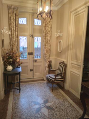 pasillo con silla y puerta con ventanas en Beausejour, en Lézignan-Corbières