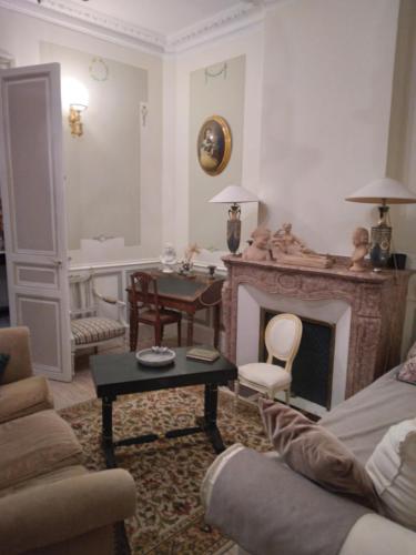 sala de estar con sofá y chimenea en Beausejour, en Lézignan-Corbières
