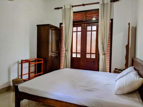 een slaapkamer met een groot bed en een raam bij Serendip Villa Holiday Home Talalla Sri Lanka in Talalla South