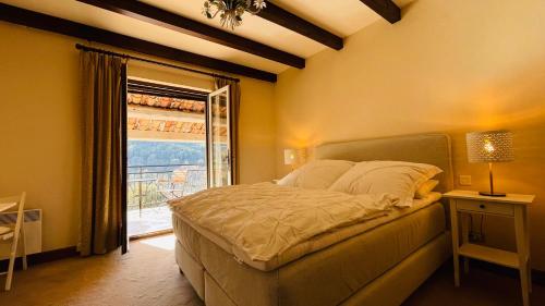 a bedroom with a large bed and a window at VILLA CAU B&B - Les Anglores in Claviers