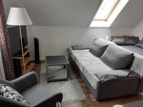 ein Wohnzimmer mit einem Sofa und einem Stuhl in der Unterkunft Seeblick Kemnitz in Werder