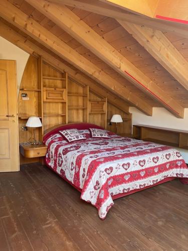 Alpino Charme Apartments في بيو: غرفة نوم بسرير كبير وسقوف خشبية