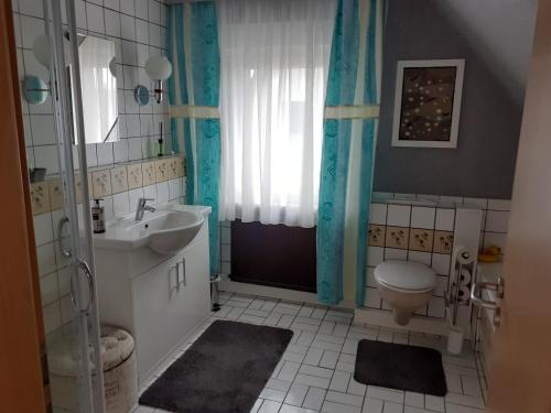 ein Bad mit einem Waschbecken, einem WC und einem Fenster in der Unterkunft Seeblick Kemnitz in Werder