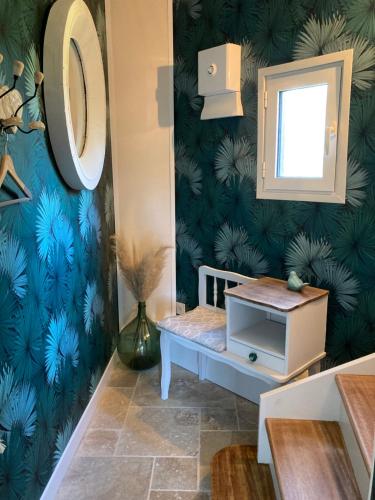 ein Bad mit einem Spiegel und einer blauen Wand in der Unterkunft Le nid 