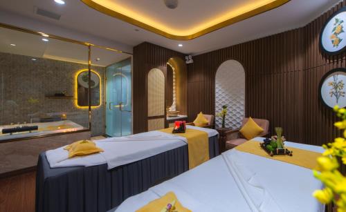 a hotel room with two beds and a tub at Grand Tourane Nha Trang Hotel in Nha Trang