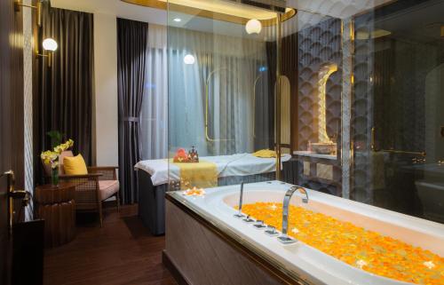 a bathroom with a bath tub filled with orange objects at Grand Tourane Nha Trang Hotel in Nha Trang