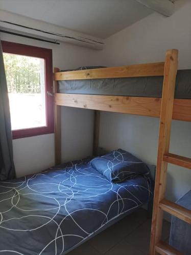 une chambre avec deux lits superposés et une fenêtre dans l'établissement n°2 Gîte 4 personnes* au cœur de la nature, à Saint-Aubin-de-Nabirat