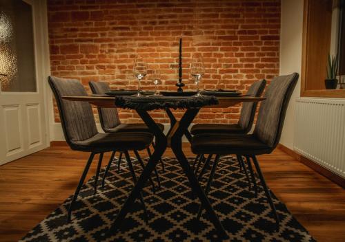 a dining room table with four chairs and a candle on it at Grossmann Apartment in Ljutomer