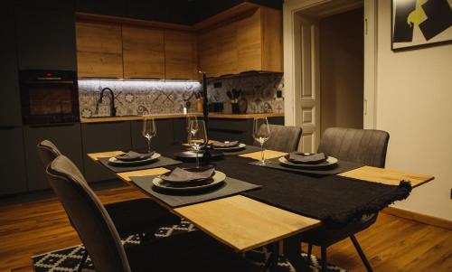 Grossmann Apartment في ليوتومير: طاولة طعام مع كراسي وطاولة قماش سوداء