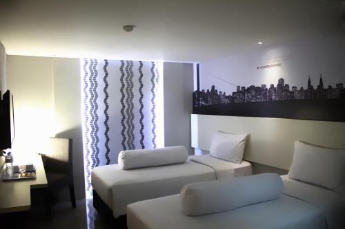 a hotel room with two beds and a couch at Vio Veteran in Bandung