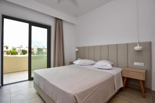 ein Schlafzimmer mit einem Bett und einem großen Fenster in der Unterkunft Rosemary Apartments in Palaiochóra