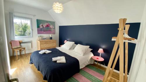 een slaapkamer met een bed met een blauwe muur bij Les Baigneurs du Crotoy in Le Crotoy