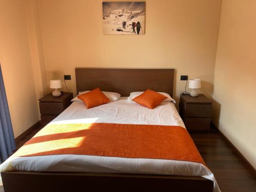 a bedroom with a large bed with orange pillows at B & B Sul Lago in Porlezza