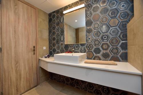 uma casa de banho com um lavatório e um espelho em Rosemary Apartments em Palaiochora