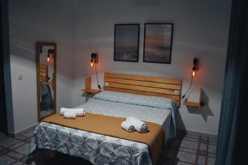 1 dormitorio con 1 cama con toallas en Aljibe Morisco - Casa Rural -, en Hornachos