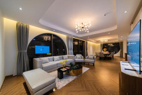a living room with a couch and a tv at Grand Tourane Nha Trang Hotel in Nha Trang