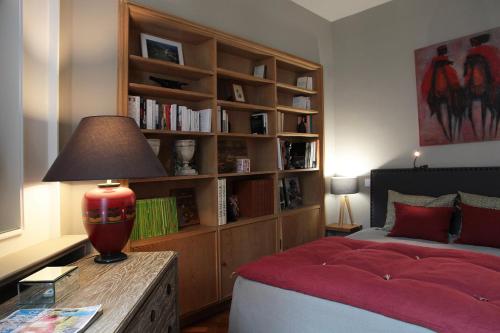 a bedroom with a bed and a book shelf at Maison d'hôtes Bordeaux Centre Le Patio de l'Intendance in Bordeaux
