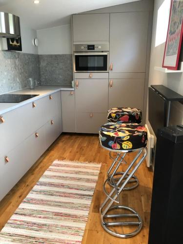 a kitchen with a counter and a stool in it at Körsbärskällan in Trosa