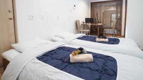 - un groupe de trois lits dans une chambre dans l'établissement KAMON INN HIRATACHO, à Kyoto