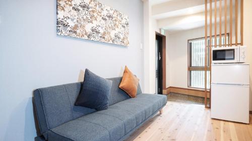 a blue couch in a living room with a microwave at 伏見稲荷平田町 in Kyoto