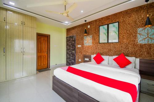 a bedroom with a large bed with red pillows at Flagship Sunshine Stay in Bhubaneshwar
