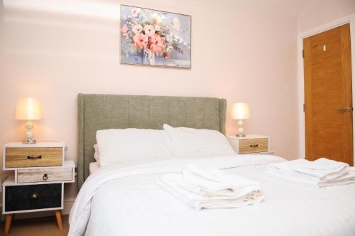 - une chambre avec un lit blanc et 2 tables de chevet dans l'établissement Luxury 5 Star London Apartment - Parking, Garden, nr Greater London Metro Stations, à Forest Hill