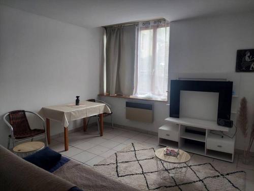 een woonkamer met een bank en een tv bij Fresnay-sur-Sarthe: joli appartement au calme. in Fresnay-sur-Sarthe