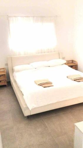 białe łóżko w pokoju z oknem w obiekcie מעיין על הנחל - נופש בקיבוץ w mieście Ha-Goszerim