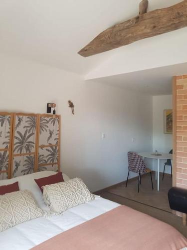 une chambre avec un lit et une table avec une chaise dans l'établissement Domaine de la Gasse - gite et chambre d'hôte, à Sainte-Cécile