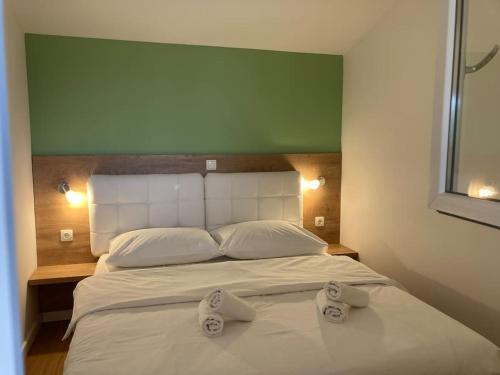 Un dormitorio con una cama blanca con dos toallas encima. en Mobilna kuća Lostura 2+1, en Murter