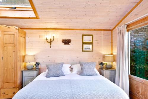 1 dormitorio con 1 cama con 2 mesitas de noche y una ventana en The Lodge - Luxury Lodge with Super King Size Bed, Kitchen & Shower Room en Hurstpierpoint
