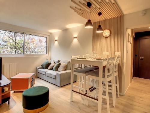 une cuisine et un salon avec une table et un canapé dans l'établissement Appartement Ancely tout neuf déco aéro - parking gratuit - Proche Blagnac, à Toulouse