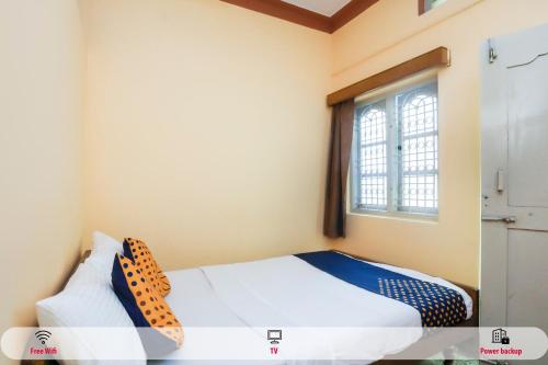 sypialnia z łóżkiem i oknem w obiekcie OYO Renuka Lodge w mieście Belagula