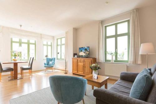 a living room with a couch and a table and chairs at Villa Frohsinn App 15 in Bansin