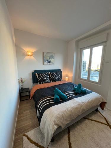 een slaapkamer met een groot bed met blauwe teddyberen erop bij Charmant appartement T2 cosy climatisé in Brive-la-Gaillarde