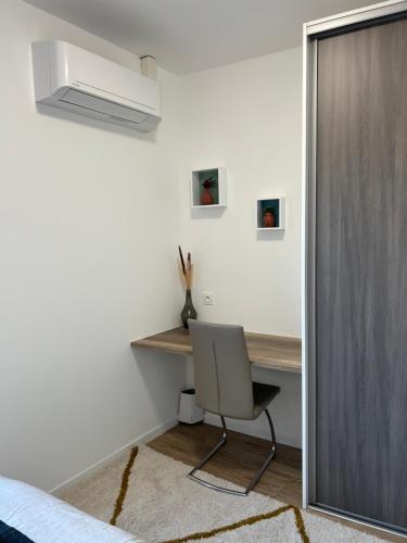 ein Schlafzimmer mit einem Schreibtisch und einem Stuhl in einem Zimmer in der Unterkunft Charmant appartement T2 cosy climatisé in Brive-la-Gaillarde