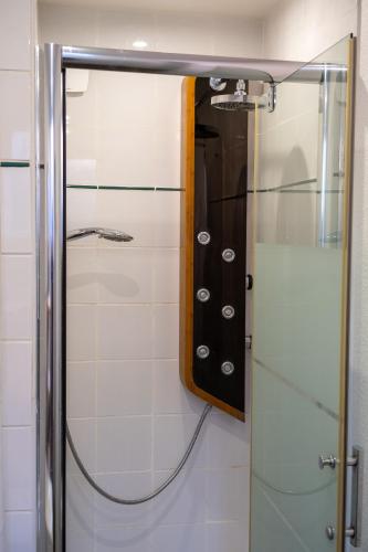 d'une douche avec une porte en verre et un miroir. dans l'établissement Appartement Saint-Sauveur, à Dinan