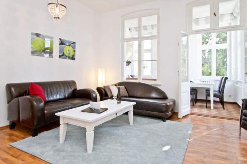 Una sala de estar con un sofá de cuero y una mesa. en Villa Hartmann Drewitz, App 06, en Heringsdorf